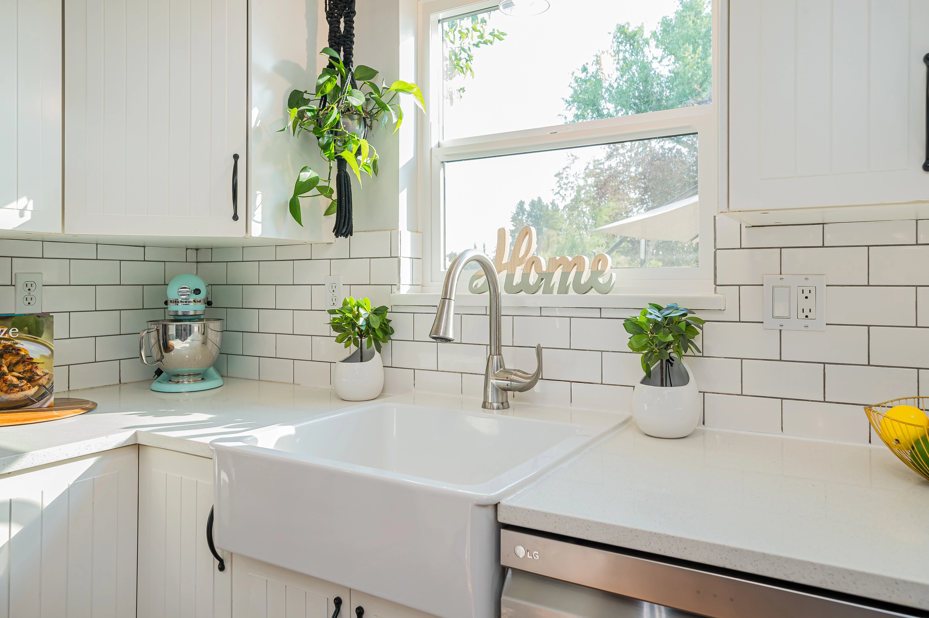 A clean, modern kitchen featuring an energy-efficient white vinyl sliding window over the sink.